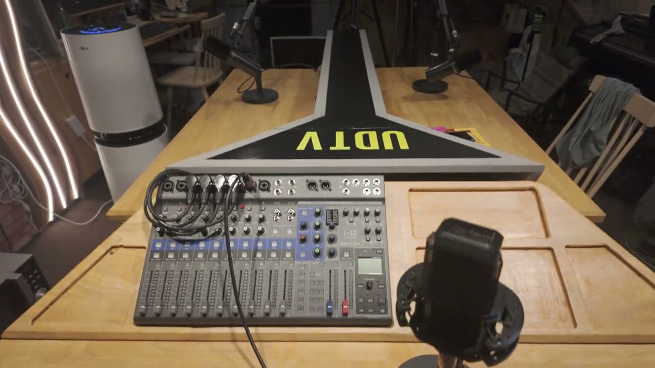 완성된 UDTv 방송용 테이블 — 상판에 UDTv 로고, 오디오 믹서와 마이크가 놓인 스튜디오 앵커 데스크